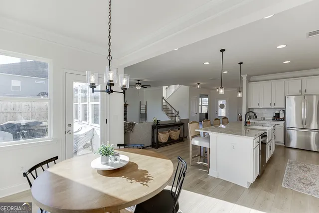 a kitchen with a dining table wooden floor dining table and appliances