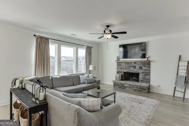 a living room with furniture a fireplace and a flat screen tv