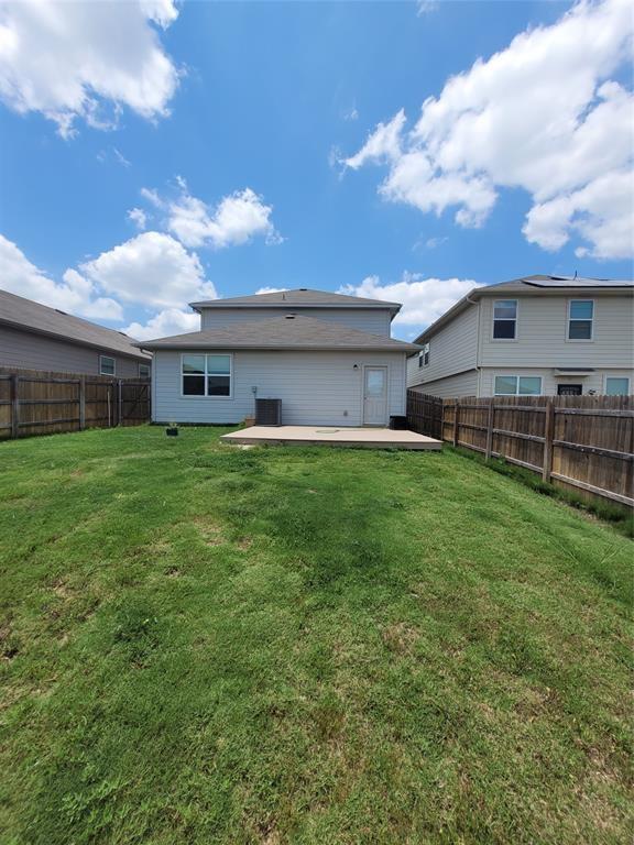 14917 Gypsum Mill Road Manor, TX 78653 - Photo 16 of 28 A spacious backyard with mature landscaping and a concrete patio, perfect for outdoor entertaining.