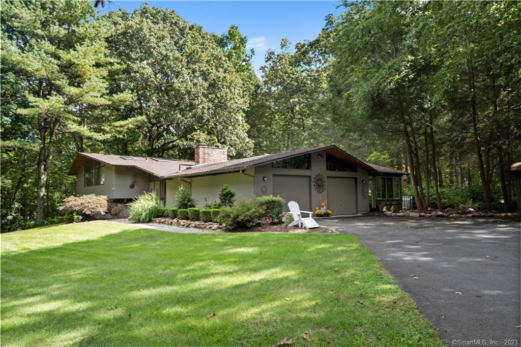 a backyard of a house with table and chairs and wooden fence