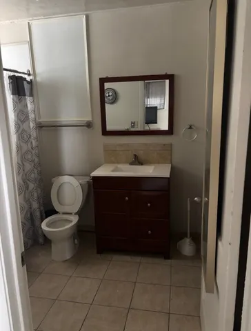 a bathroom with a toilet a sink and mirror