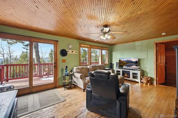 a living room with furniture a flat screen tv and a floor to ceiling window