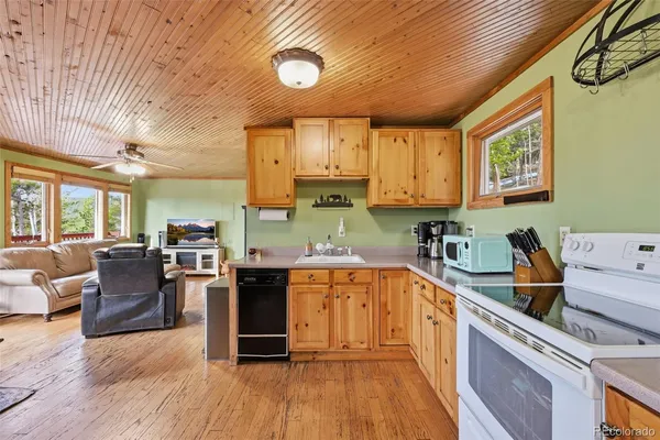 a kitchen with stainless steel appliances granite countertop wooden cabinets a stove top oven a sink and dishwasher