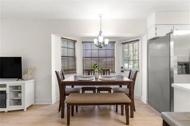 a view of a dining room and livingroom with furniture wooden floor a rug and a clock