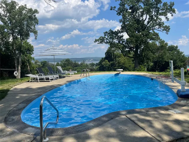 a swimming pool with outdoor seating and trees