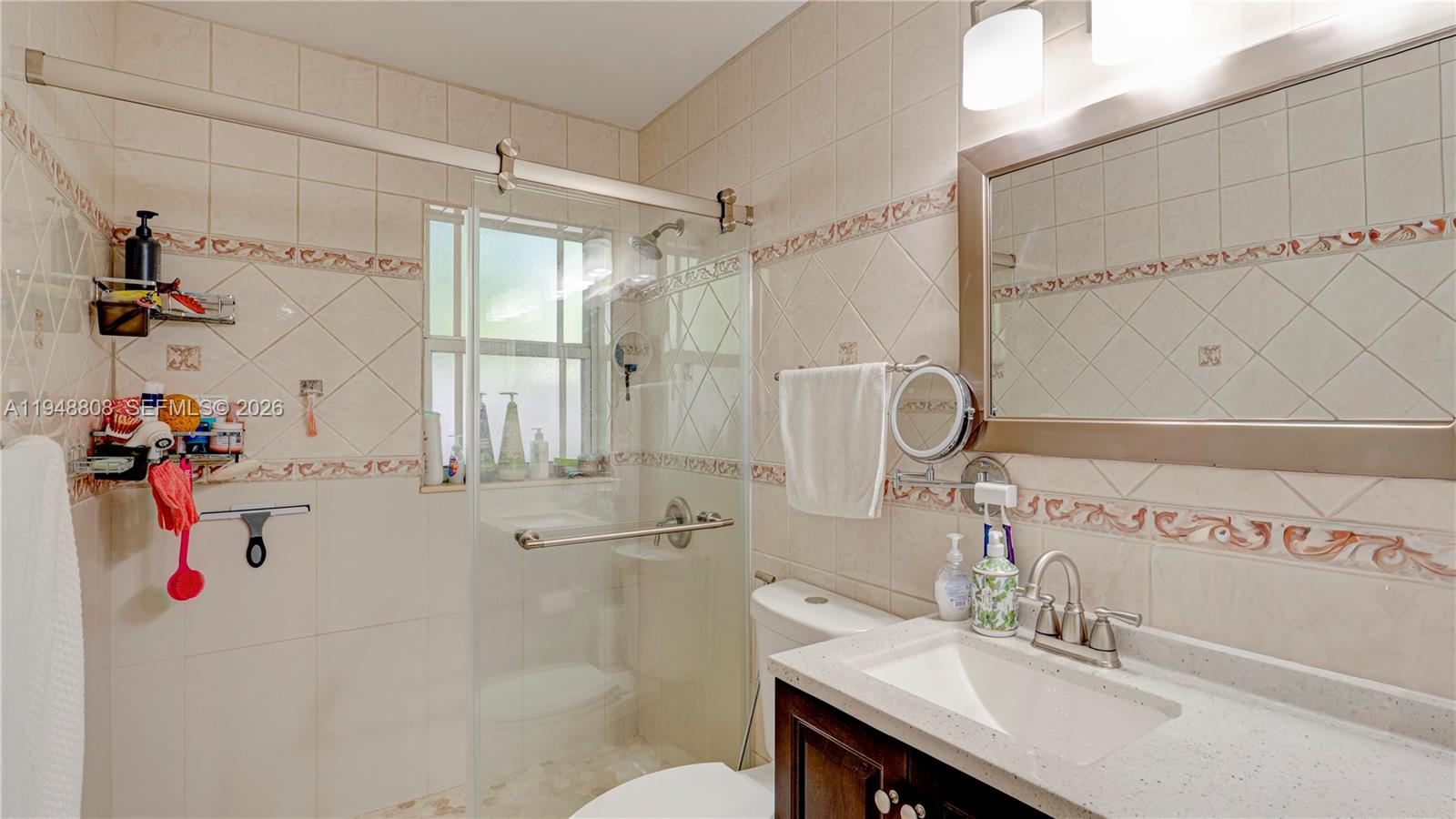6815 Southwest 134th Court Miami, FL 33183 - Photo 16 of 53 a bathroom with a sink mirror and shower