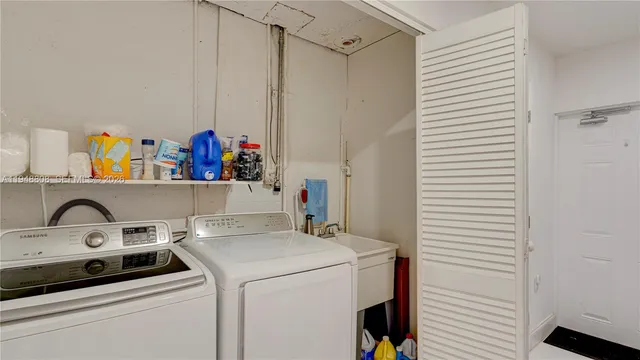 a view of a kitchen with a sink and a refrigerator