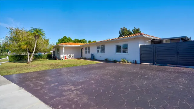 a view of a house with backyard and a tree
