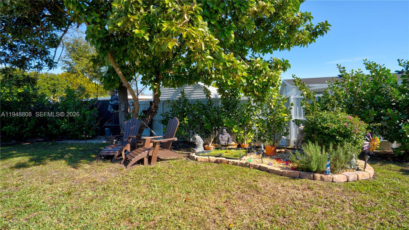 6815 Southwest 134th Court Miami, FL 33183 - Photo 39 of 53 a backyard of a house with table and chairs under an umbrella