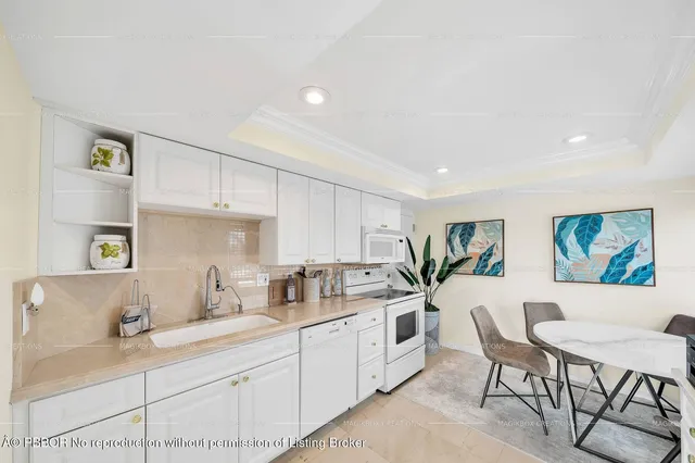 a kitchen with granite countertop white cabinets and white appliances