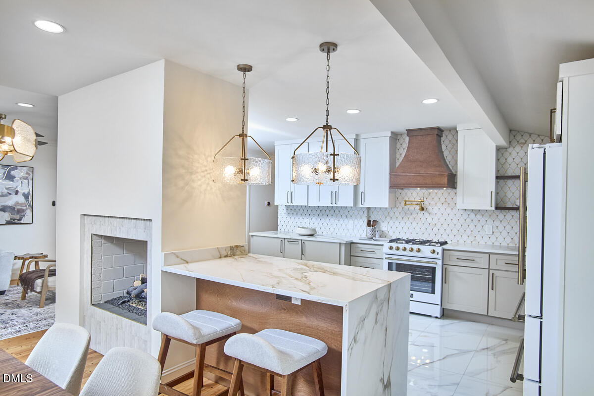 1609 Acadia Street Durham, NC 27701 - Photo 16 of 56 a kitchen with stainless steel appliances a sink a stove a refrigerator a dining table and chairs