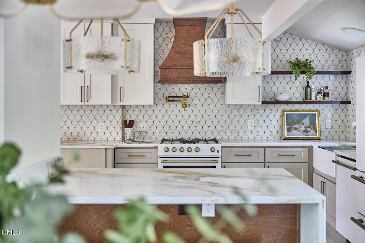 1609 Acadia Street Durham, NC 27701 - Photo 17 of 56 a kitchen with stainless steel appliances granite countertop a stove a sink and a microwave