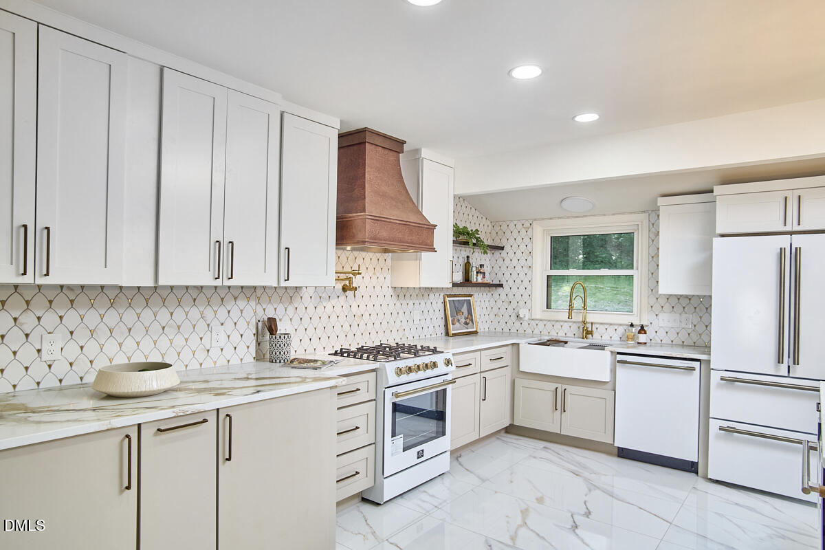 1609 Acadia Street Durham, NC 27701 - Photo 19 of 56 a kitchen with white cabinets stainless steel appliances and sink