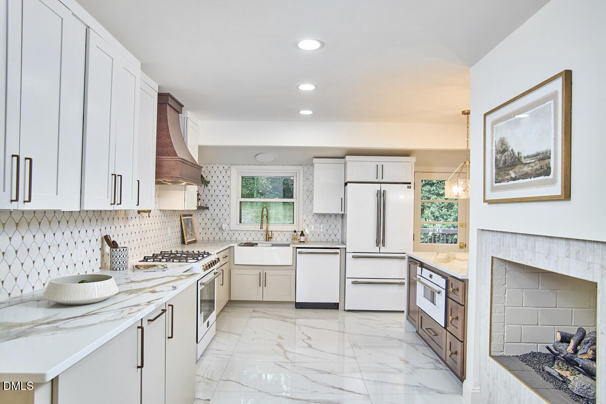 1609 Acadia Street Durham, NC 27701 - Photo 21 of 56 a kitchen with white cabinets and white appliances