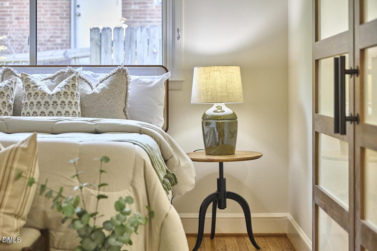 1609 Acadia Street Durham, NC 27701 - Photo 32 of 56 a bedroom with a bed and a table in it