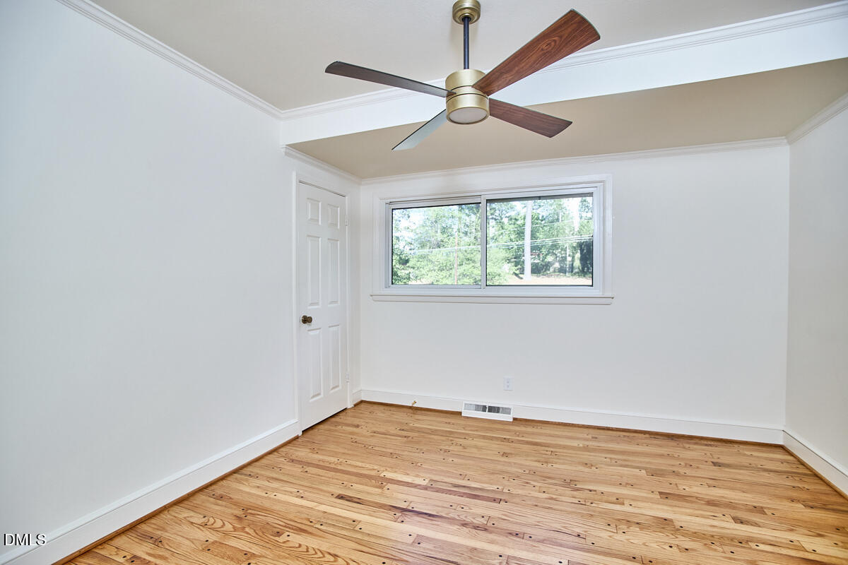 1609 Acadia Street Durham, NC 27701 - Photo 56 of 56 an empty room with wooden floor fan and windows