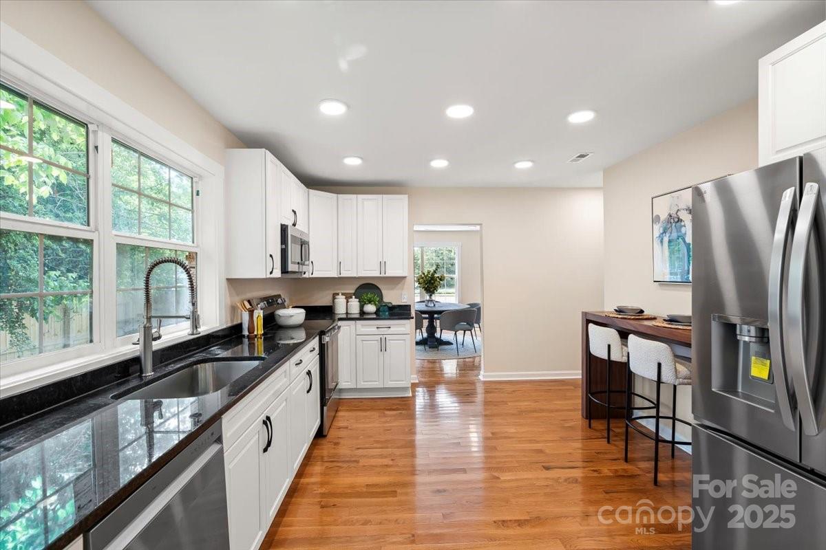 6034 Tuckaseegee Road Charlotte, NC 28208 - Photo 14 of 35 a kitchen with stainless steel appliances granite countertop a refrigerator a sink dishwasher a stove and white countertops with wooden floor