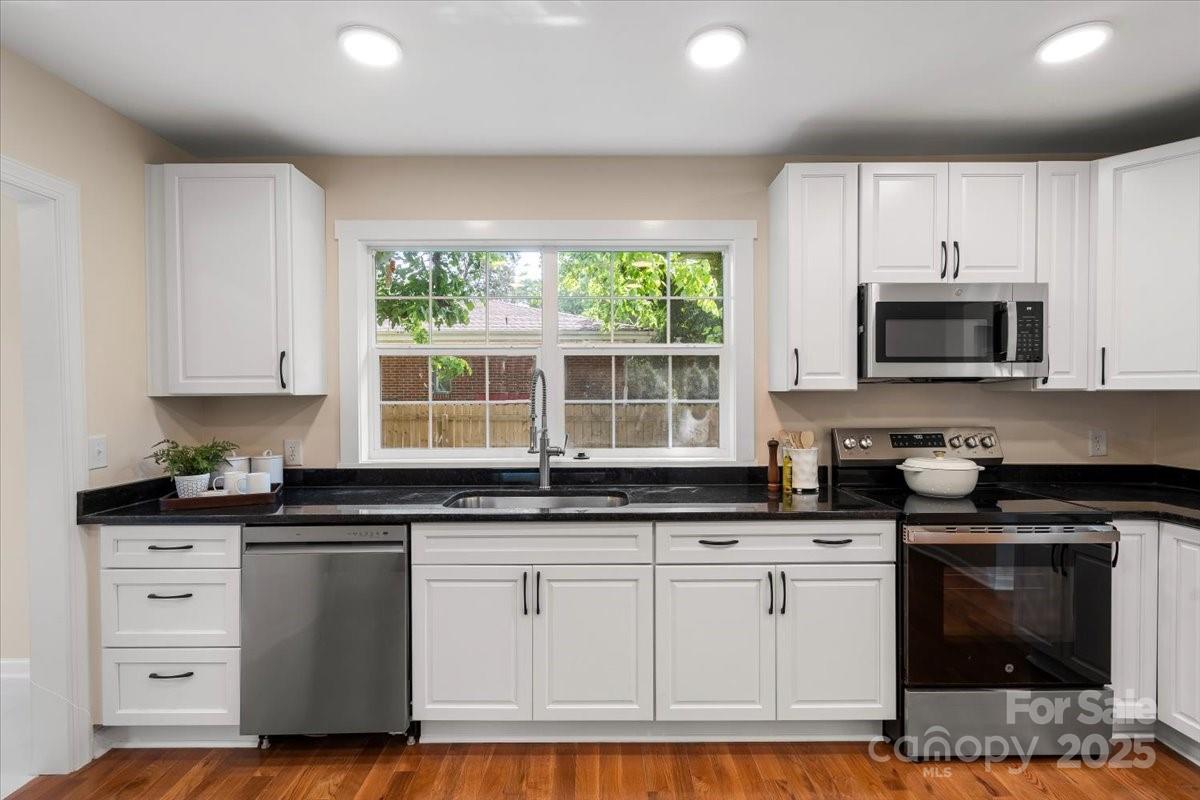 6034 Tuckaseegee Road Charlotte, NC 28208 - Photo 16 of 35 a kitchen with granite countertop white cabinets and appliances