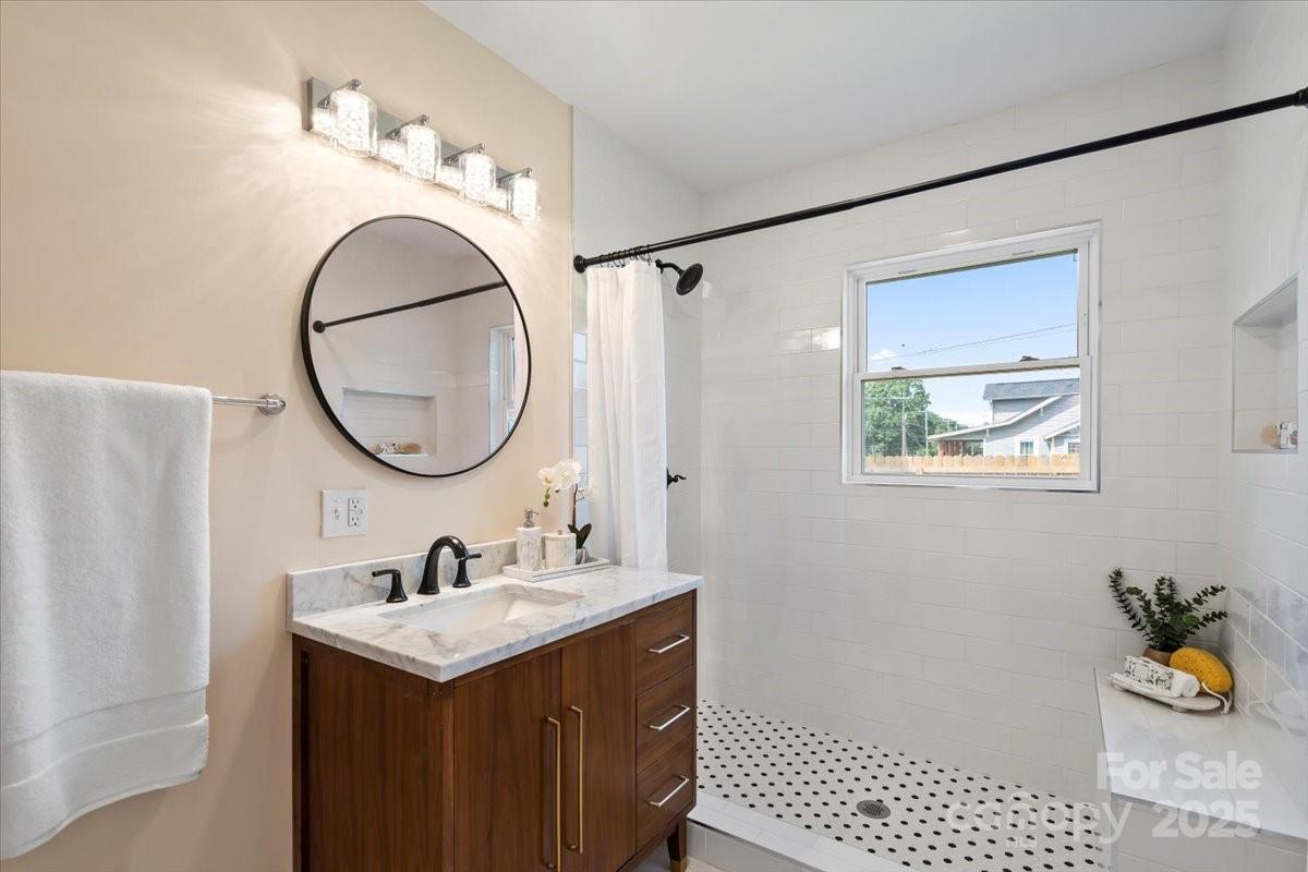 6034 Tuckaseegee Road Charlotte, NC 28208 - Photo 22 of 35 a bathroom with a sink a mirror and a shower