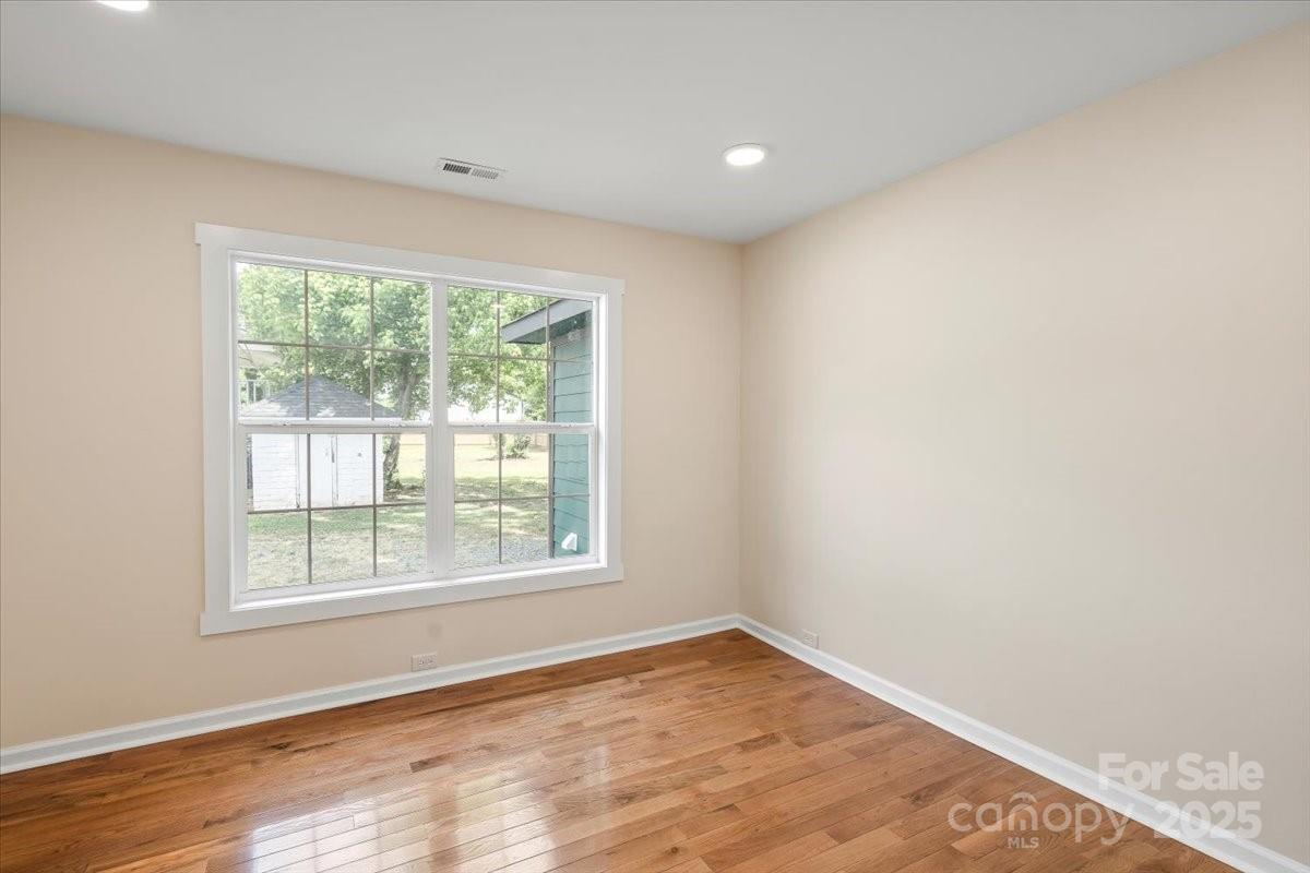 6034 Tuckaseegee Road Charlotte, NC 28208 - Photo 26 of 35 a view of an empty room with wooden floor and a window