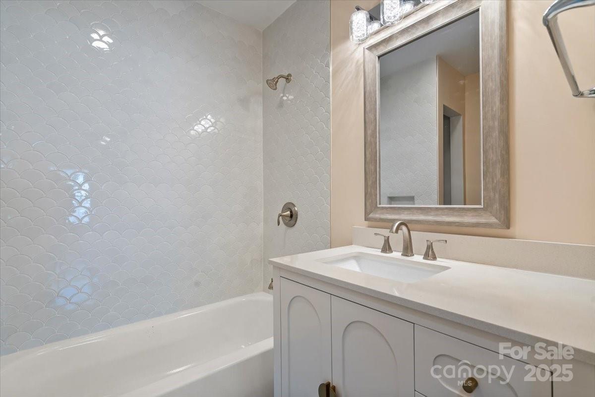 6034 Tuckaseegee Road Charlotte, NC 28208 - Photo 28 of 35 a bathroom with a bathtub a sink and a mirror