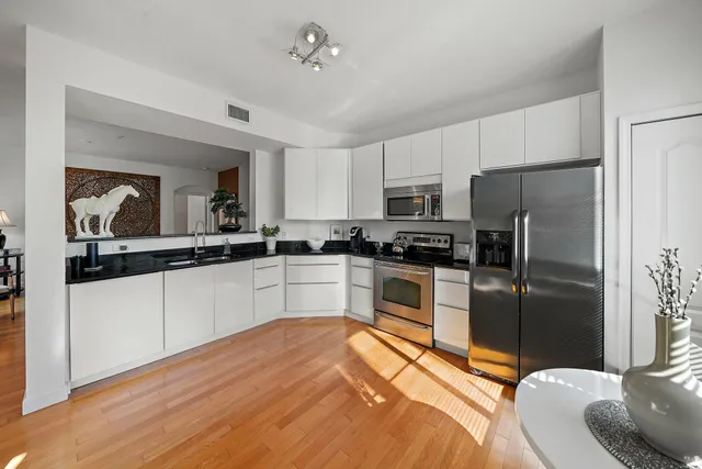 a kitchen with a refrigerator cabinets and wooden floor