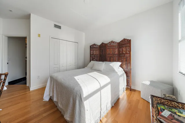 a bedroom with a bed and wooden floor