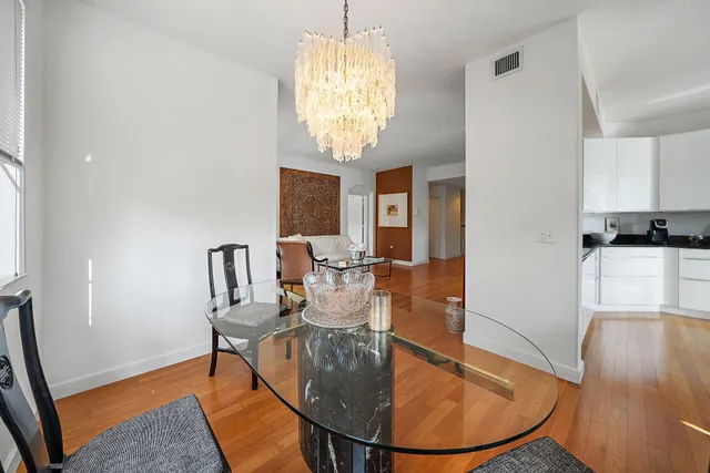 a view of a dining room with furniture a chandelier and wooden floor