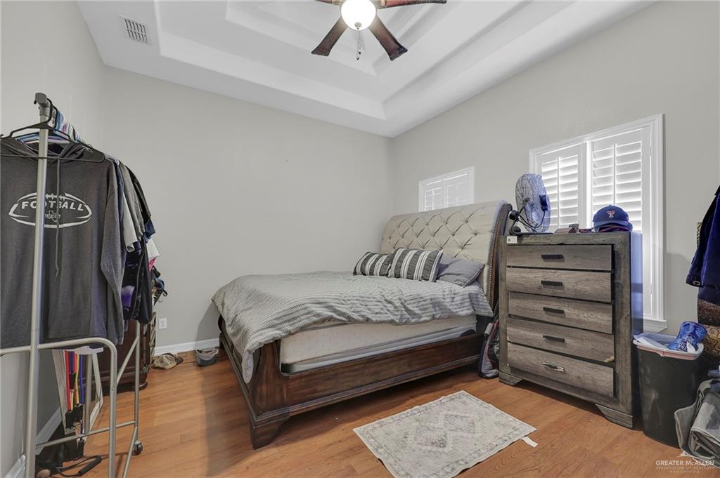12813 North 106th Street Mission, TX 78573 - Photo 12 of 17 Bedroom with wood finished floors, a raised ceiling, and a ceiling fan