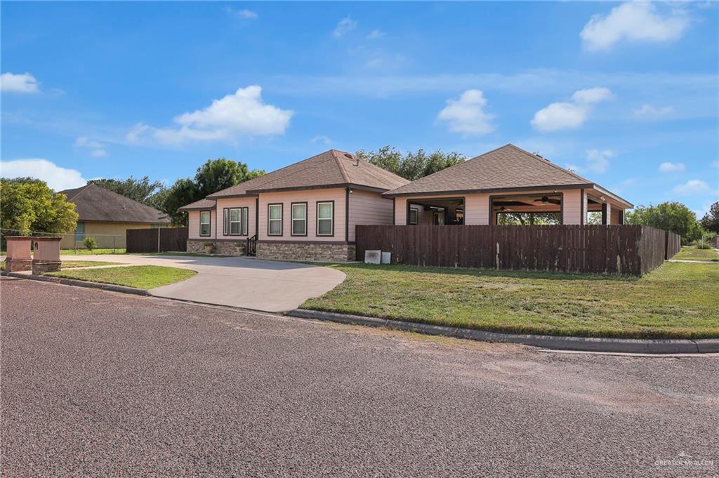 12813 North 106th Street Mission, TX 78573 - Photo 2 of 17 View of front of property featuring roof with shingles, stone siding, and driveway