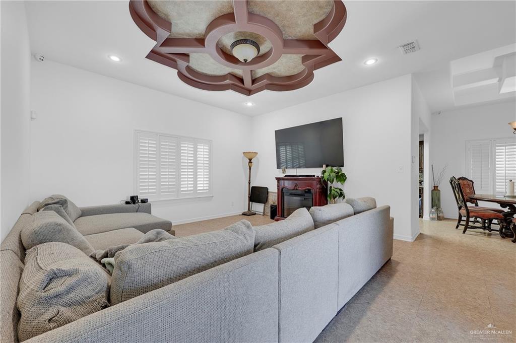 12813 North 106th Street Mission, TX 78573 - Photo 4 of 17 Living area featuring recessed lighting, coffered ceiling, and a glass covered fireplace