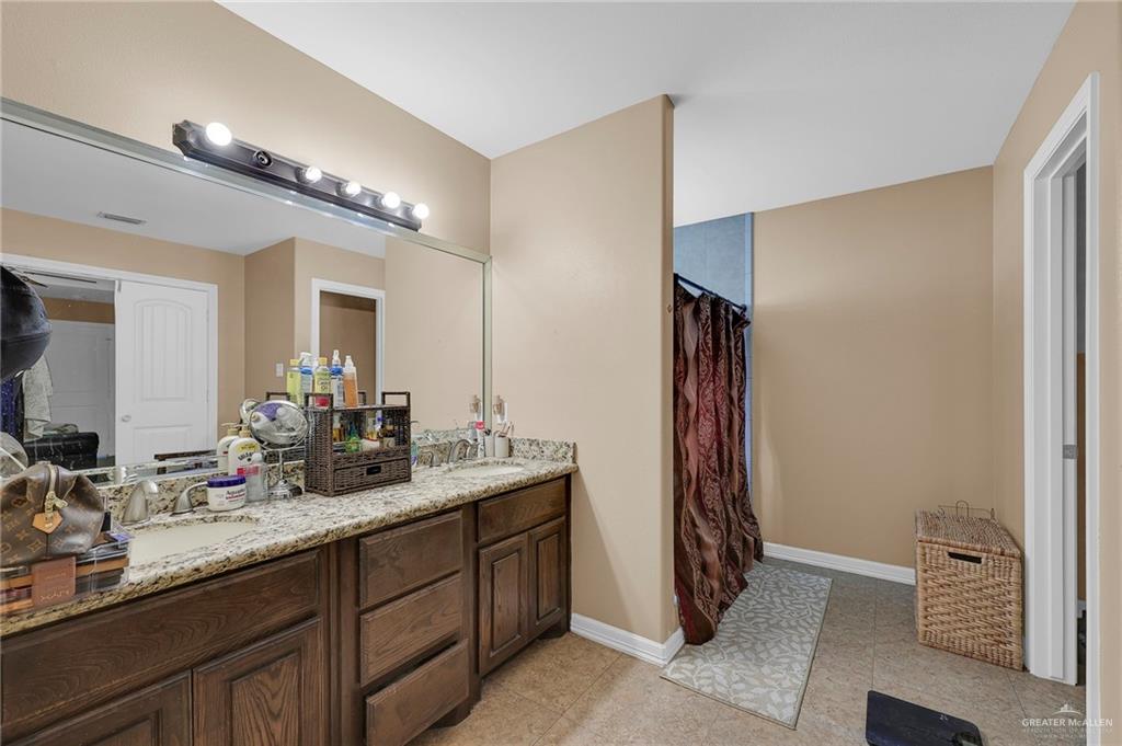 12813 North 106th Street Mission, TX 78573 - Photo 10 of 17 Full bath with double vanity, curtained shower, and light tile patterned floors