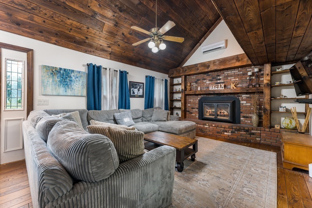 385 Mendell Road Rochester, MA 02770 - Photo 8 of 27 a living room with furniture a fireplace and a large window
