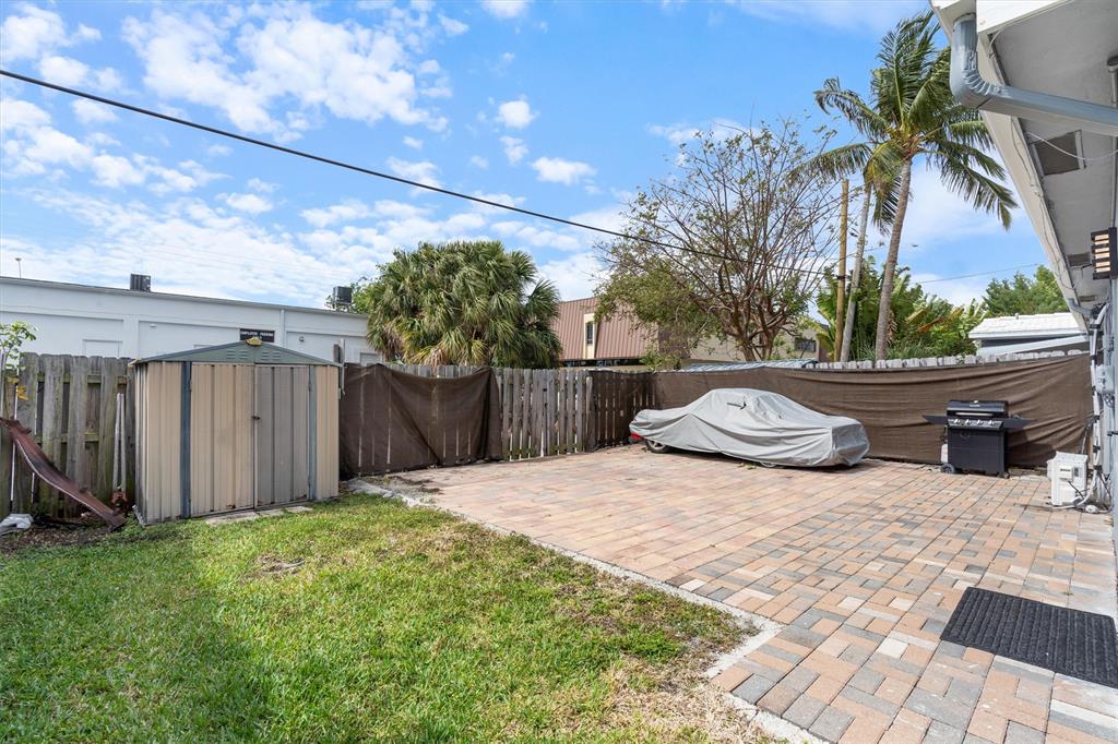 2242 Northeast 37th Street Lighthouse Point, FL 33064 - Photo 20 of 22 a view of backyard of house with wooden fence and potted plants