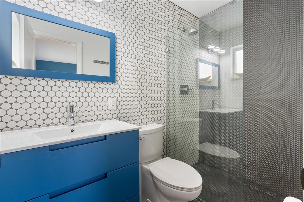 2242 Northeast 37th Street Lighthouse Point, FL 33064 - Photo 7 of 22 a bathroom with a sink a toilet and mirror