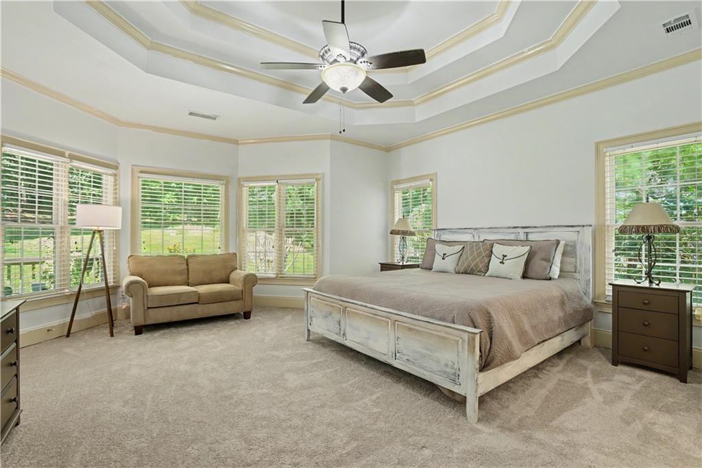 537 Old Collins Road Hoschton, GA 30548 - Photo 18 of 42 a bedroom with a bed a couch and a large window