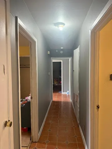 a view of a hallway with wooden shelves