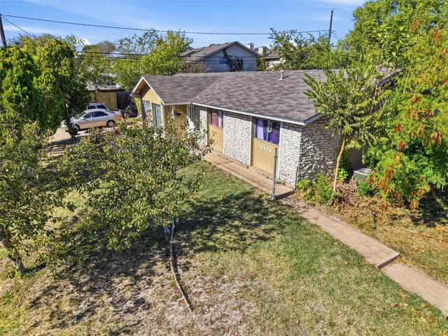 a aerial view of a house with a yard and potted plants