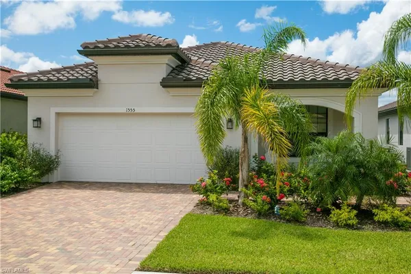 a view of a house with a yard and potted plants
