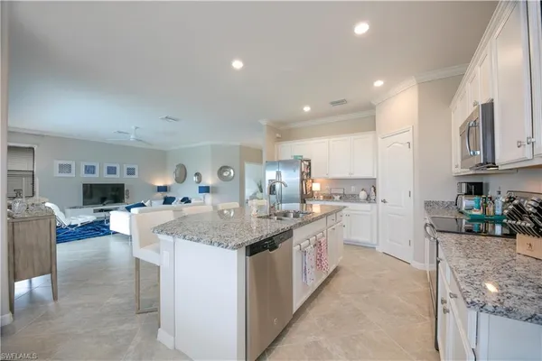 a kitchen with stainless steel appliances granite countertop a sink dishwasher stove refrigerator and cabinets