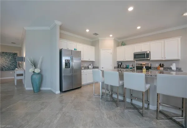 a kitchen with refrigerator and chairs