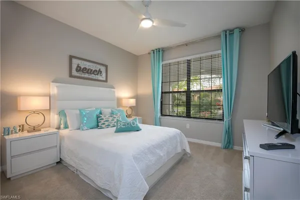 a bedroom with a bed and a flat tv screen on the dresser