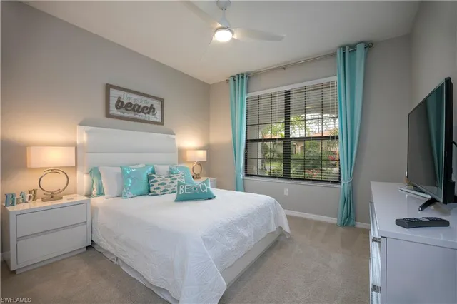 a bedroom with a bed and a flat tv screen on the dresser