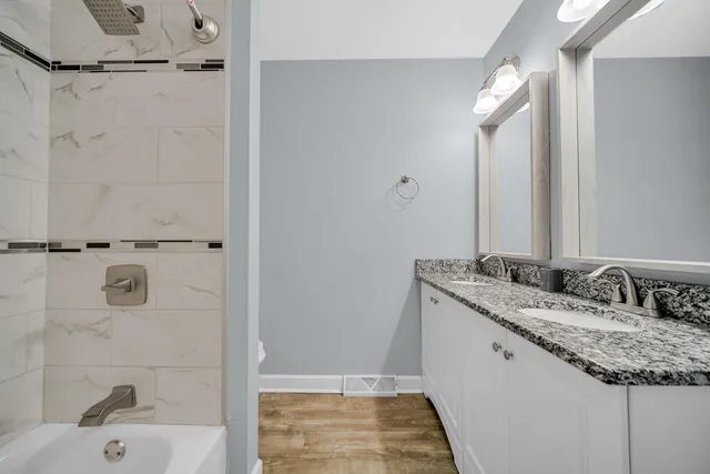 a bathroom with a granite countertop sink and a mirror