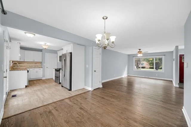a view of a kitchen and a sink wooden floor chandelier