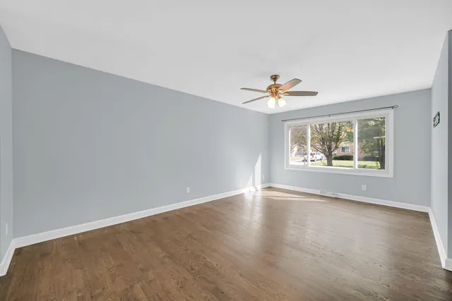 an empty room with window and ceiling fan
