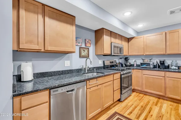 a kitchen with stainless steel appliances granite countertop a sink stove and cabinets
