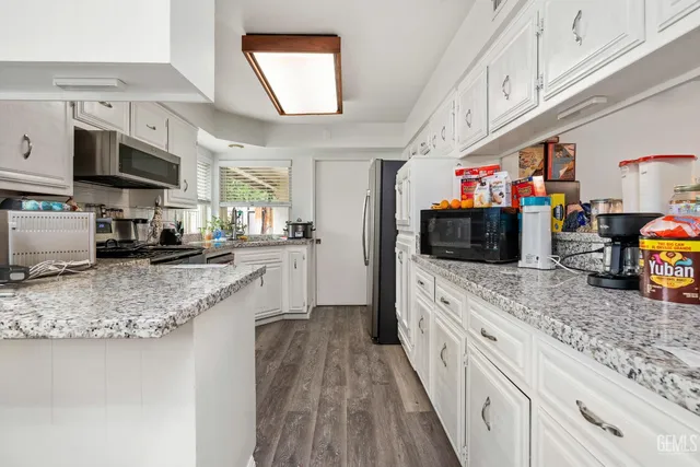 a kitchen with stainless steel appliances granite countertop a stove a sink and a microwave