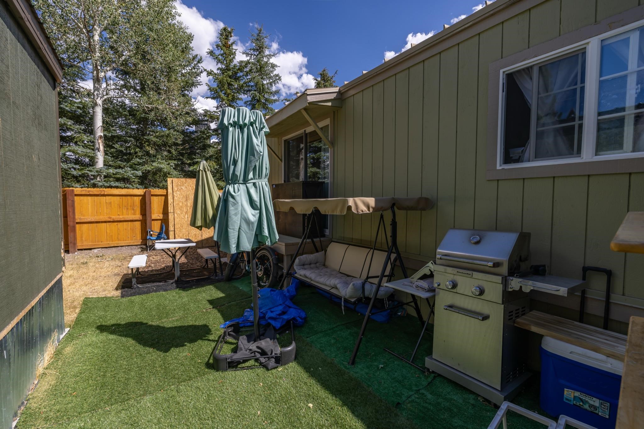 100 Ski Trails Road, Unit 10 Mammoth Lakes, CA 93546 - Photo 25 of 26 Outdoor area featuring artificial turf, a wood fence, and vertical siding