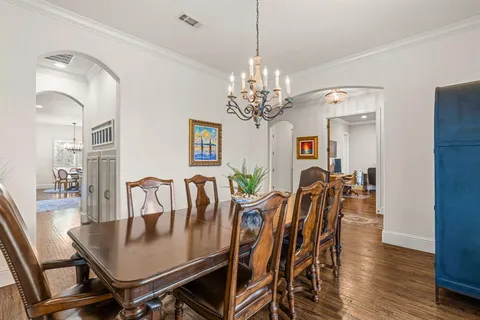 a view of a dining room with furniture wooden floor and chandelier